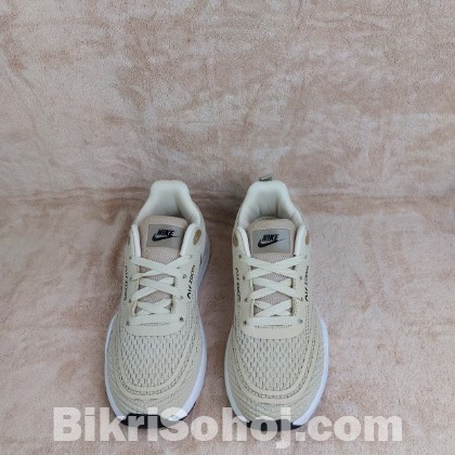 Nike Air Zoom running shoes in a light beige/tan colorway wi
